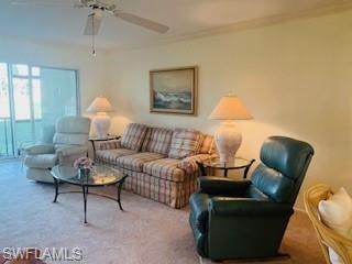 Carpeted living room featuring ceiling fan and ornamental molding