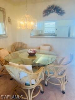 Dining space with carpet flooring and a chandelier