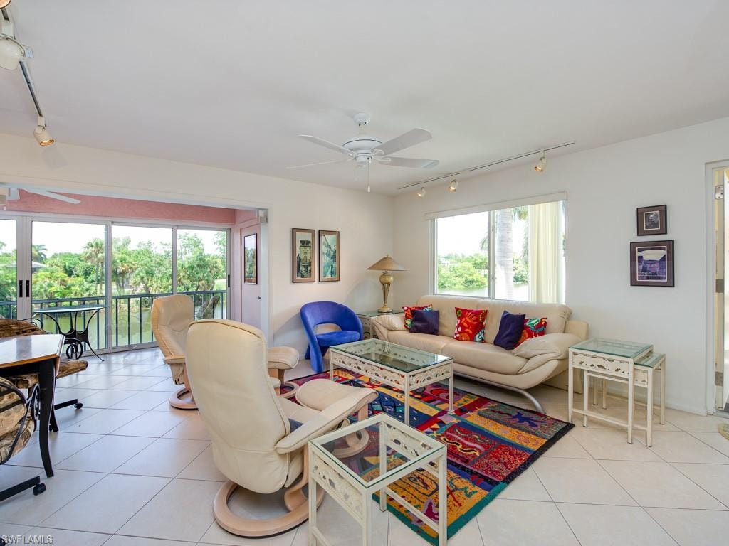 Living area with rail lighting, ceiling fan, and light tile patterned flooring