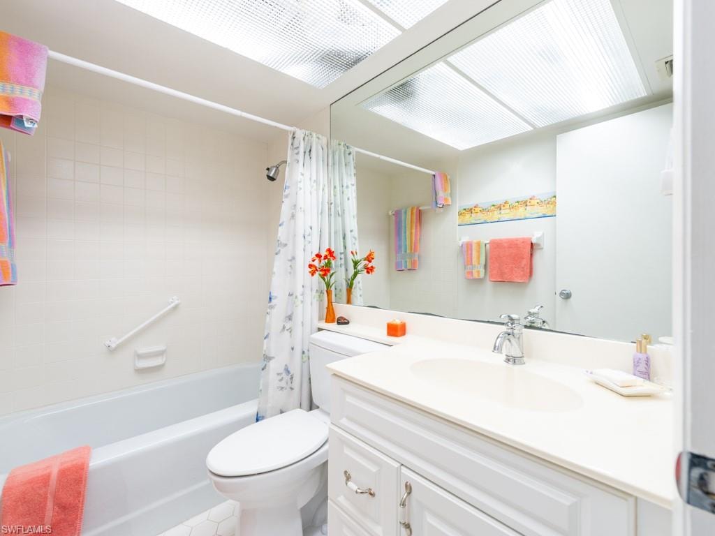 Bathroom featuring shower / bath combo, vanity, and light tile patterned flooring