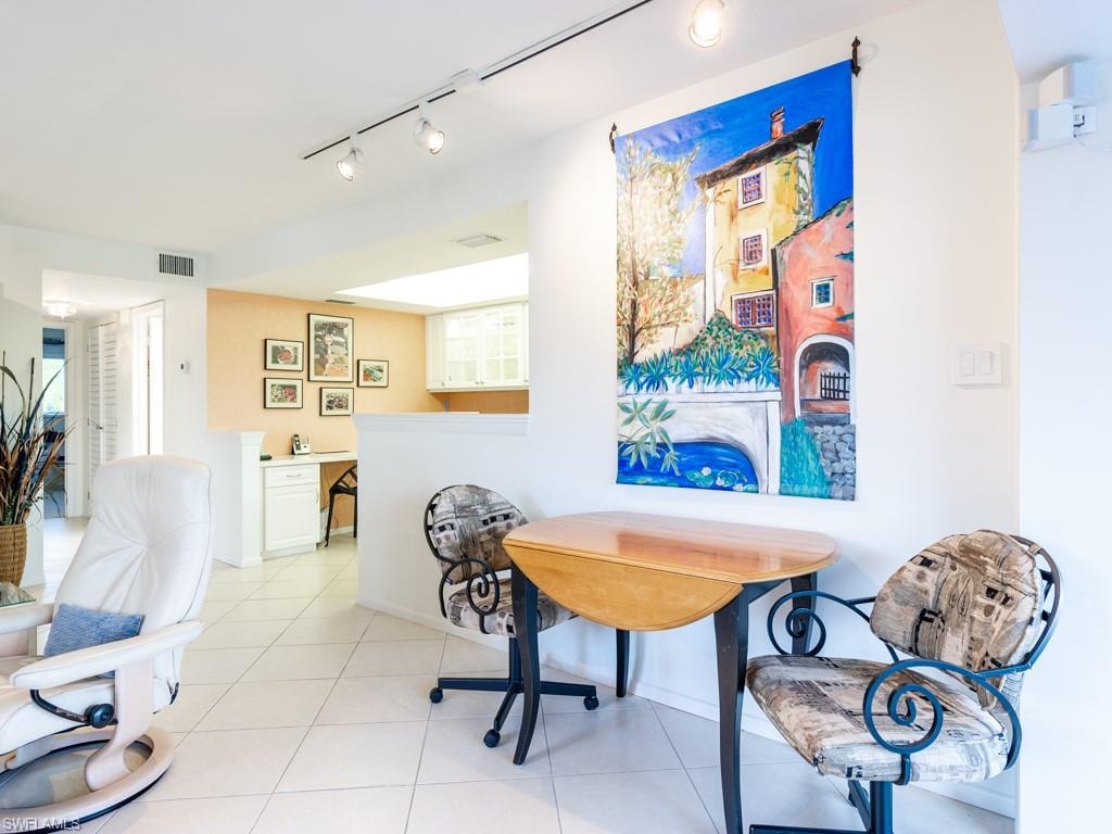 Tiled dining area with rail lighting and built in study area