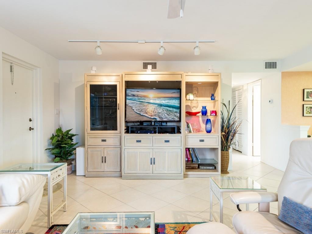 Living area featuring rail lighting and light tile patterned floors