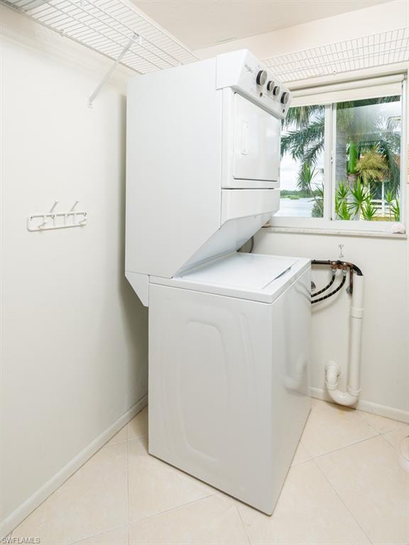 Laundry area featuring estacked washer and dryer and light tile patterned flooring