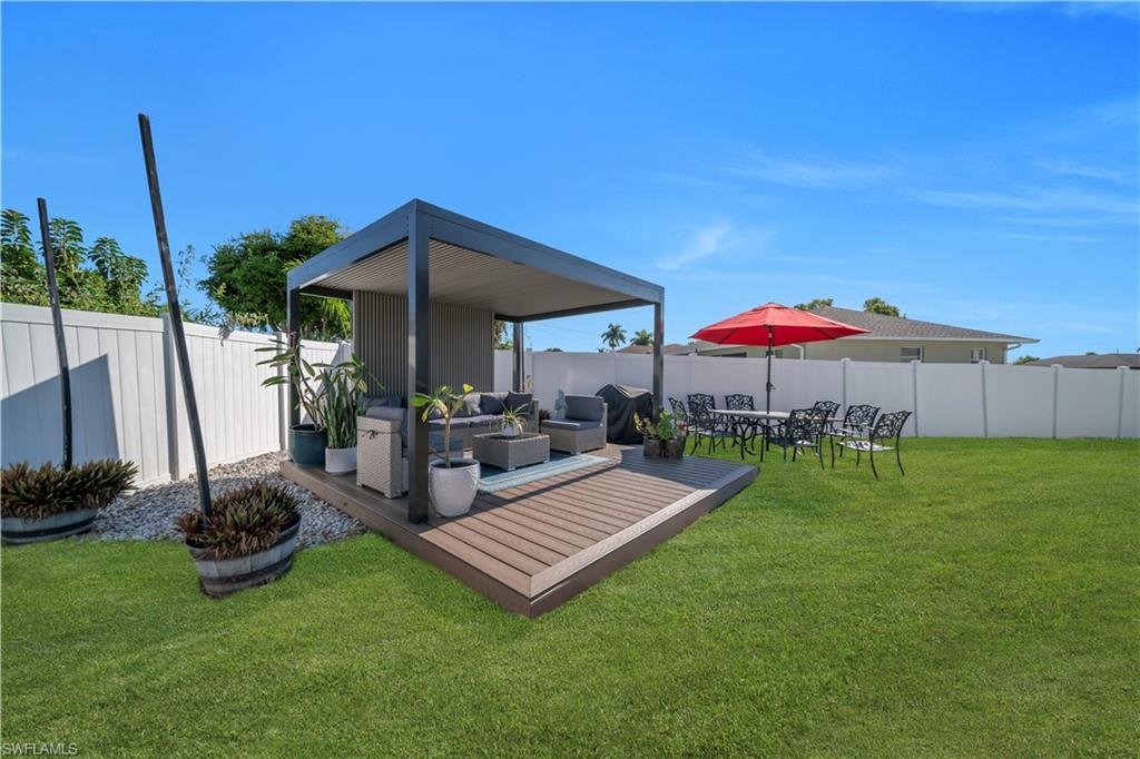 Fenced backyard featuring a deck and outdoor lounge area