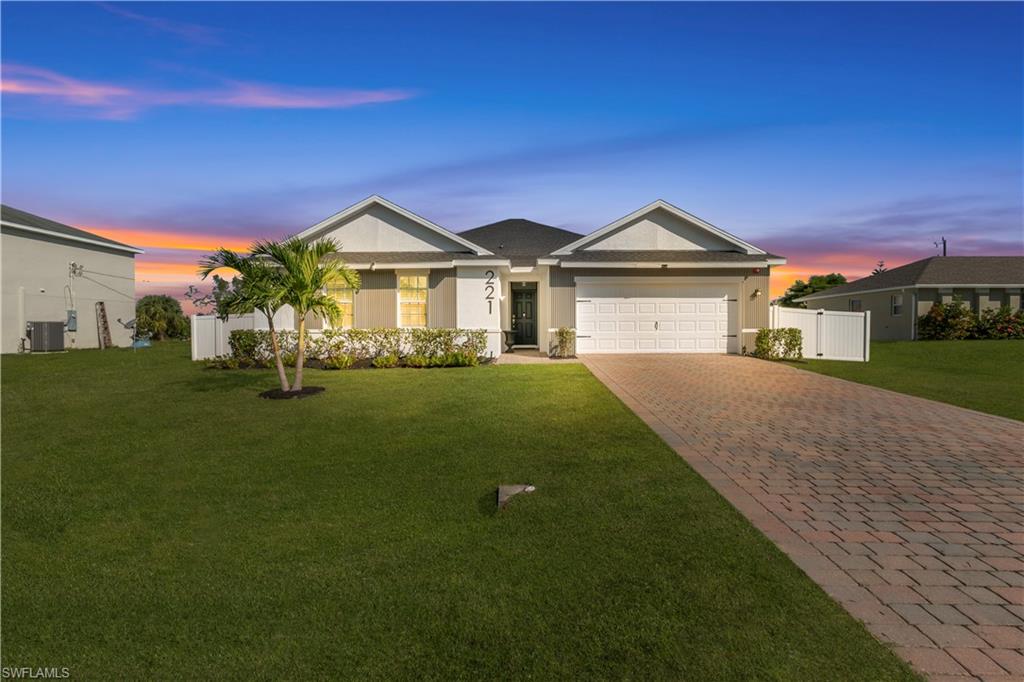 Ranch-style home featuring decorative driveway, stucco siding, and an attached garage