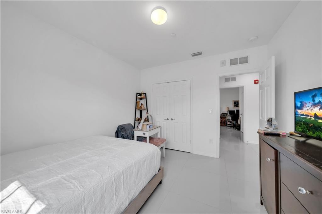 Bedroom with a desk and light tile patterned floors