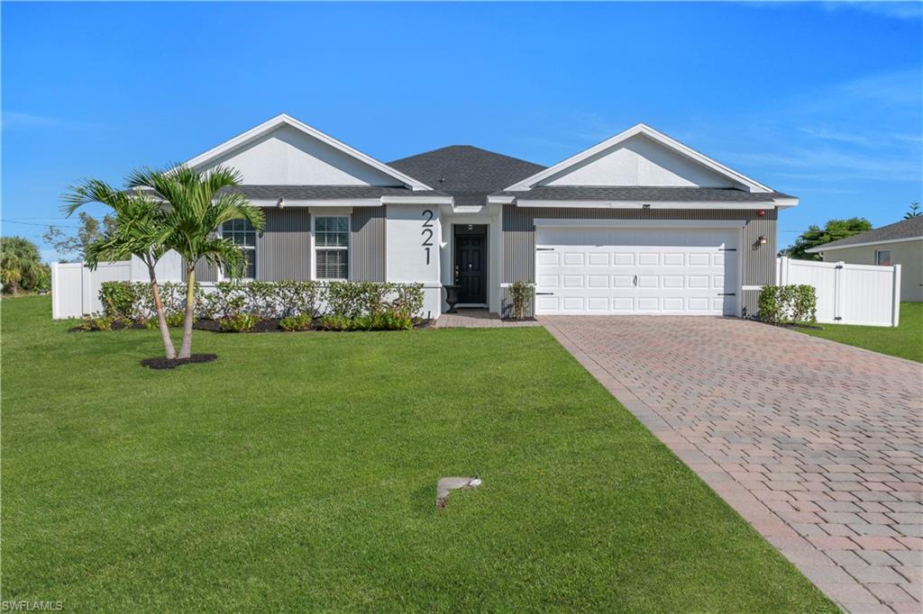 Ranch-style house featuring decorative driveway, an attached garage, and roof with shingles