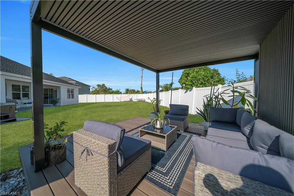 Fenced backyard with an outdoor living space and a wooden deck