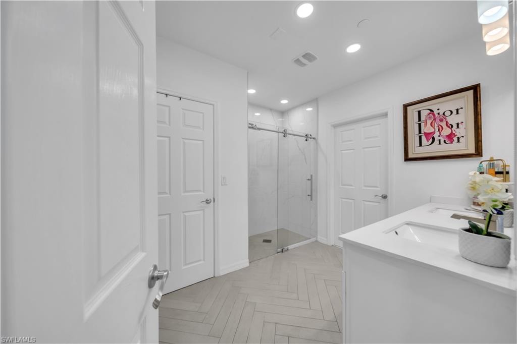 Full bath featuring a marble finish shower and recessed lighting