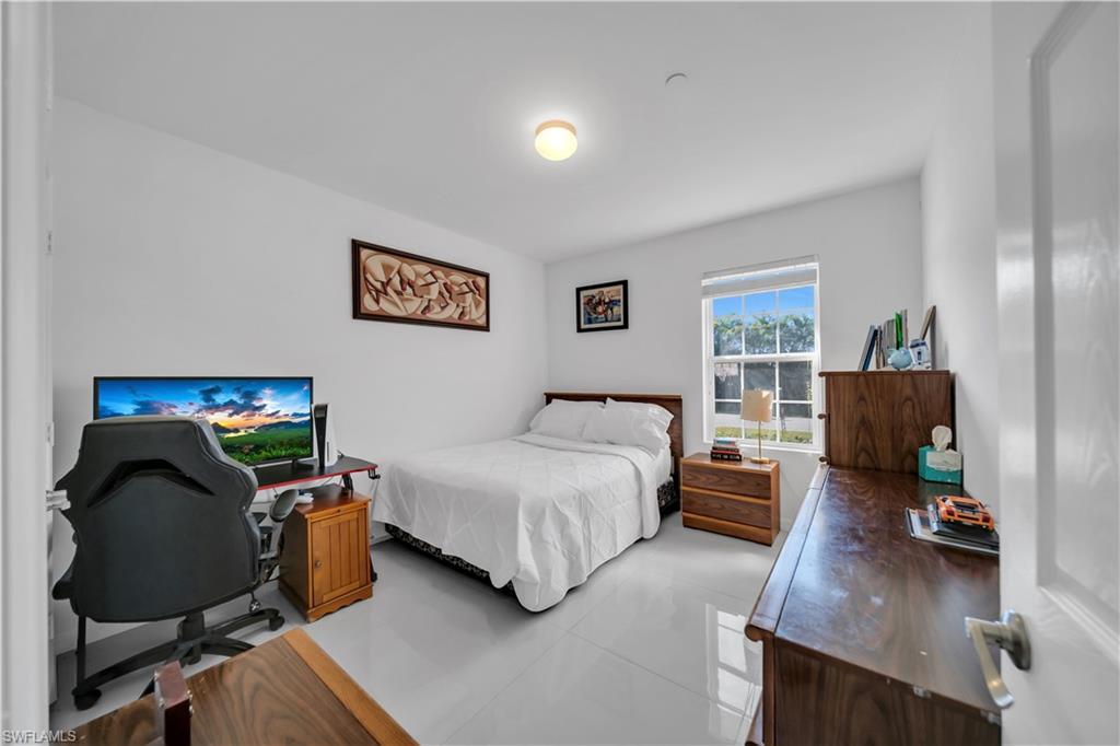 Bedroom featuring an office area, a closet, and light tile patterned flooring