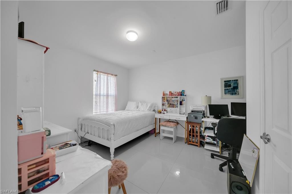 Bedroom with light tile patterned flooring