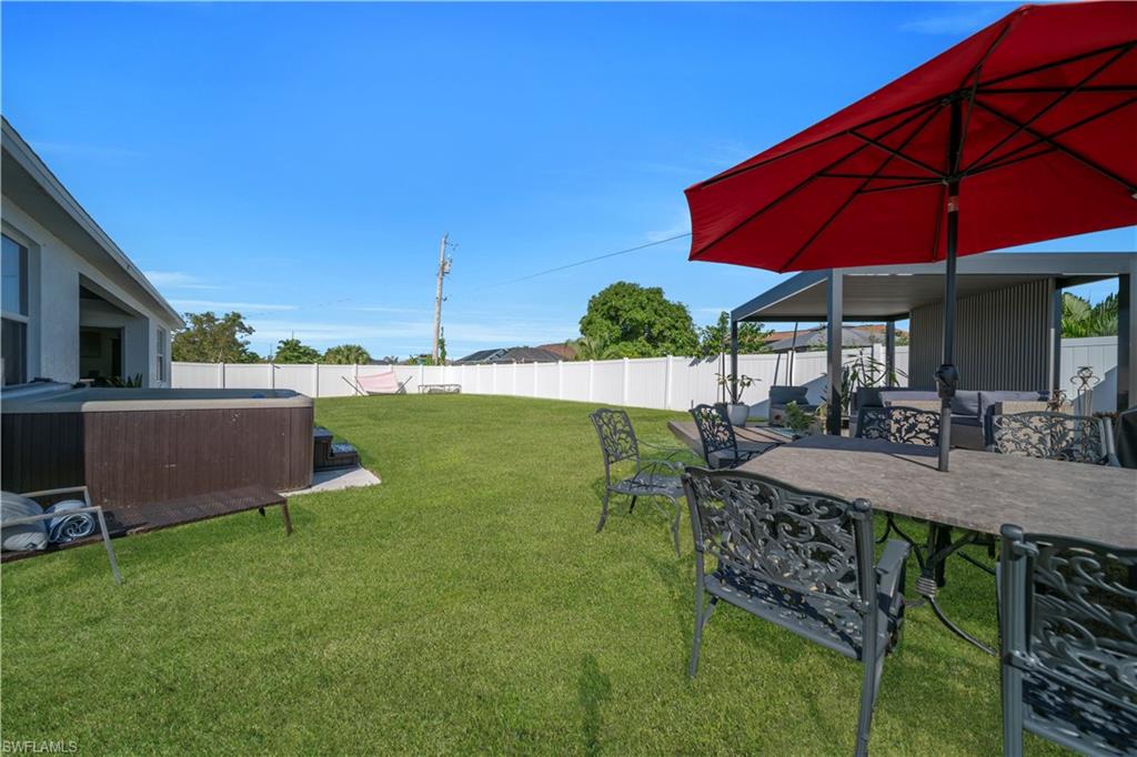 Fenced backyard featuring a patio area and a grill