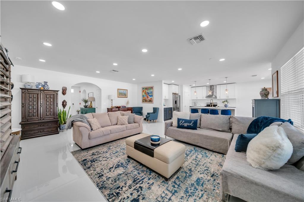 Living area featuring recessed lighting, arched walkways, and tile patterned flooring