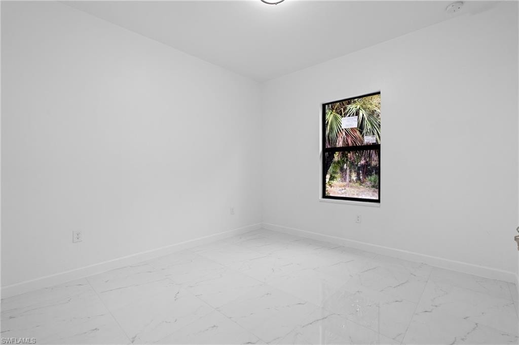 Spare room with light marble finish floors and baseboards