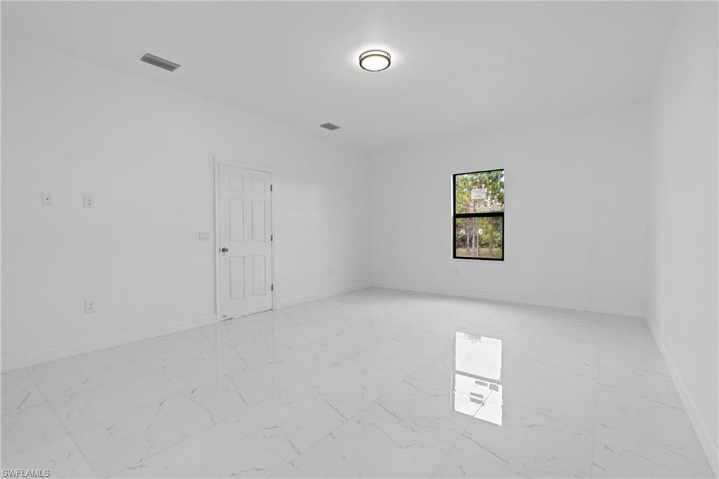 Unfurnished room with light marble finish flooring and baseboards