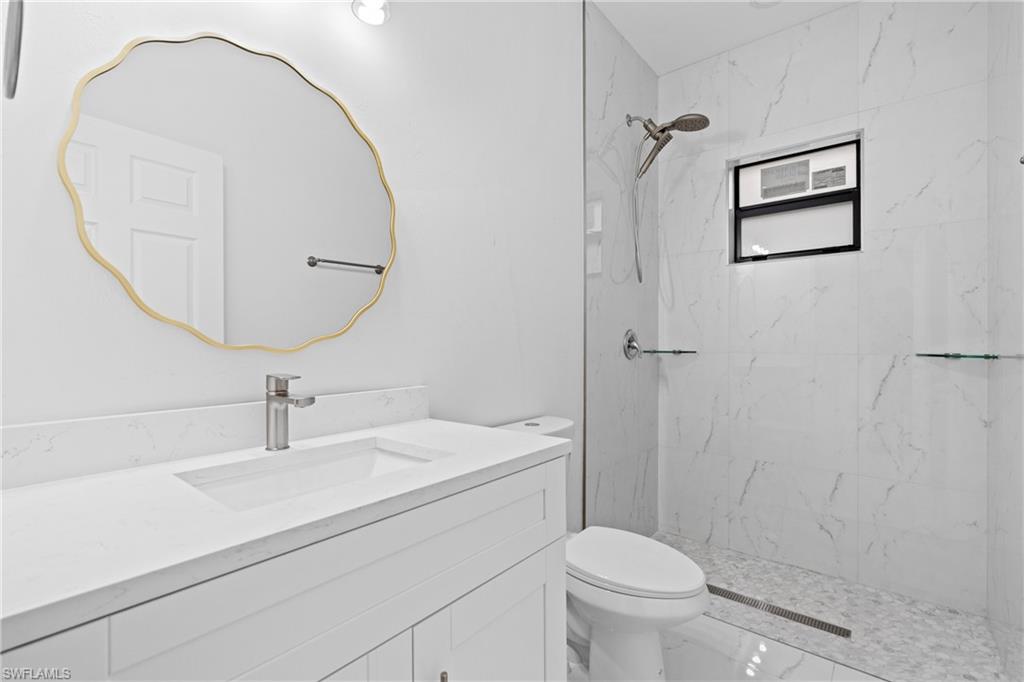 Bathroom with vanity and a marble finish shower