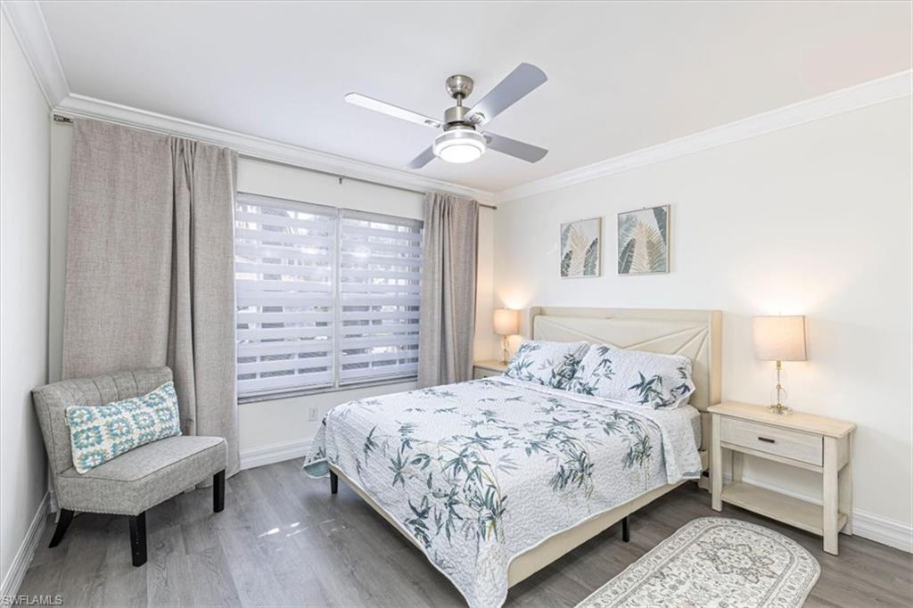 Bedroom with crown molding, wood finished floors, and a ceiling fan