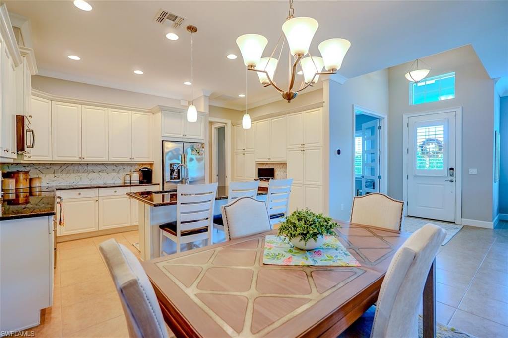 Dining area with light tile patterned floors, a chandelier, and recessed lighting
