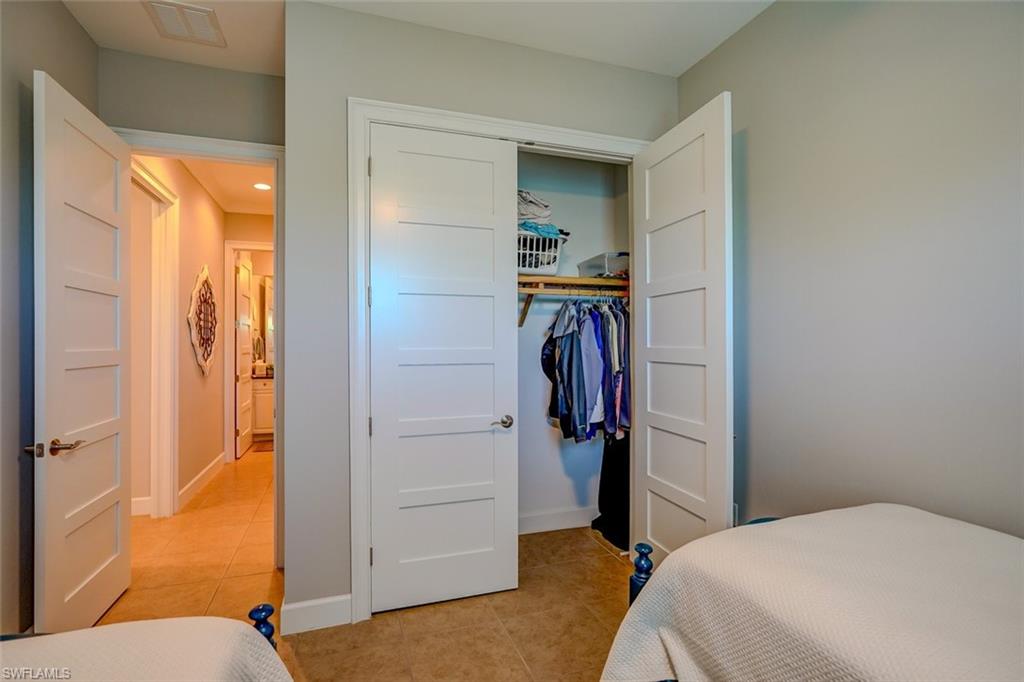 Bedroom featuring light tile patterned floors and a walk in closet