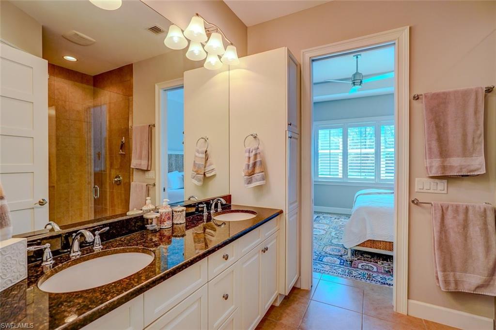 Full bath featuring double vanity, light tile patterned floors, a shower stall, and ensuite bathroom