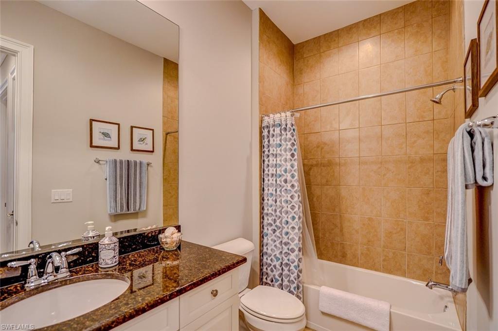 Bathroom with shower / bath combination with curtain and vanity