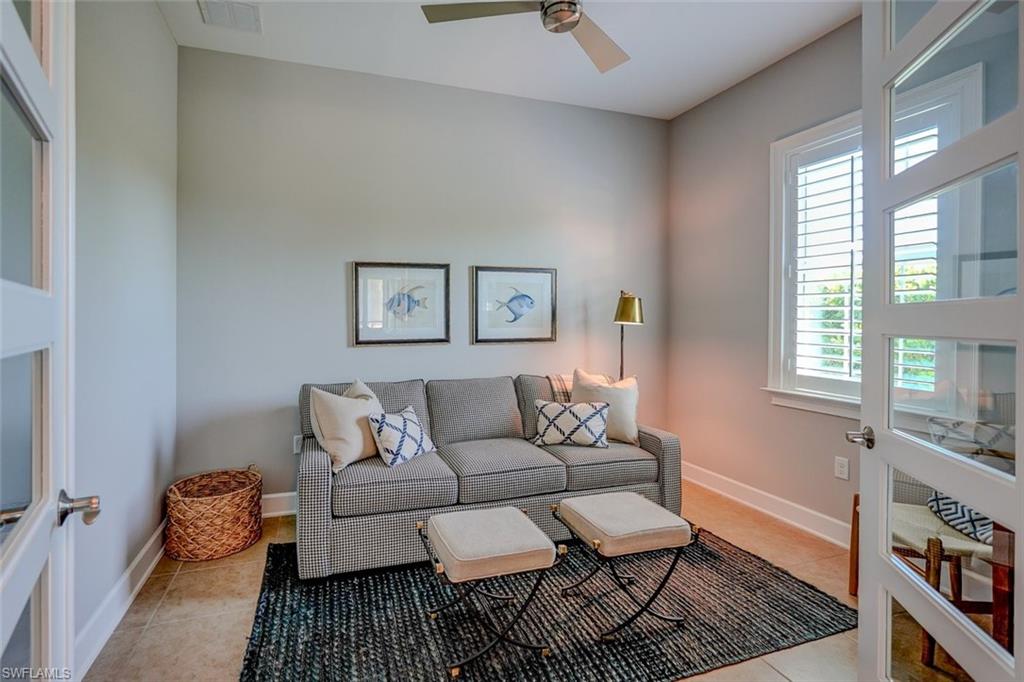 Living room with light tile patterned flooring and a ceiling fan