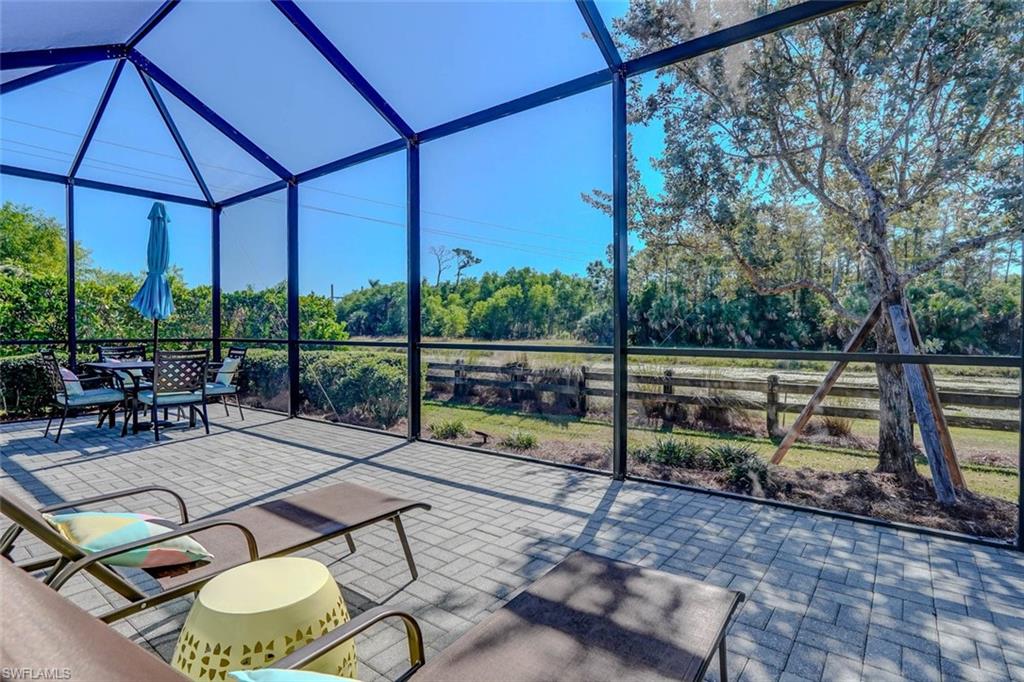View of patio / terrace with a lanai, a sunroom, and view of wooded area