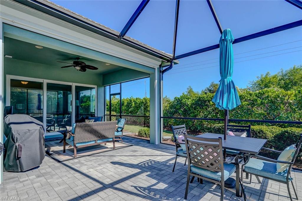 View of patio featuring a sunroom, outdoor dining area, a ceiling fan, and a lanai