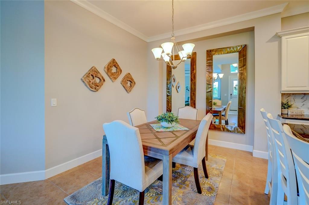 Dining room featuring a chandelier, crown molding, and light tile patterned floors