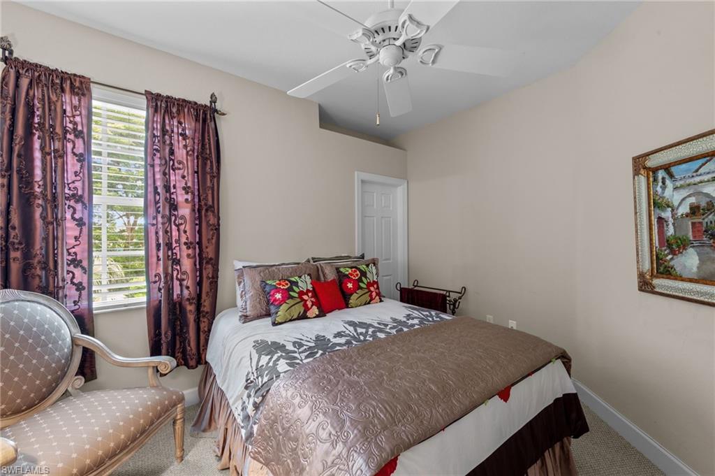 Carpeted bedroom featuring a ceiling fan and baseboards