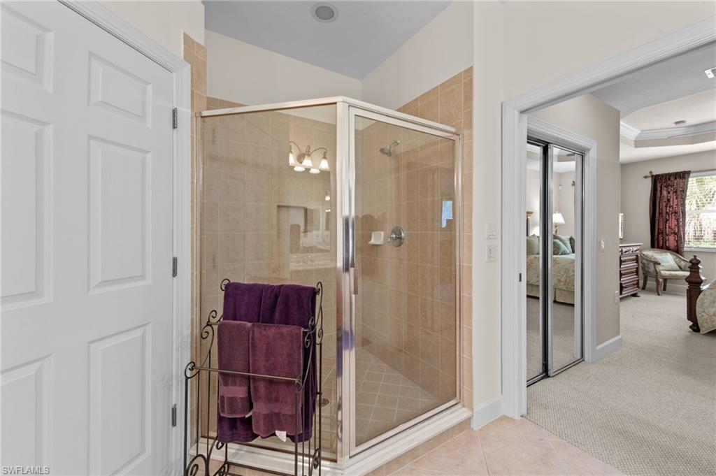 Bathroom featuring ensuite bath, carpet flooring, a shower stall, and tile patterned floors