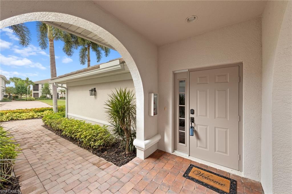 View of exterior entry featuring stucco siding and a porch