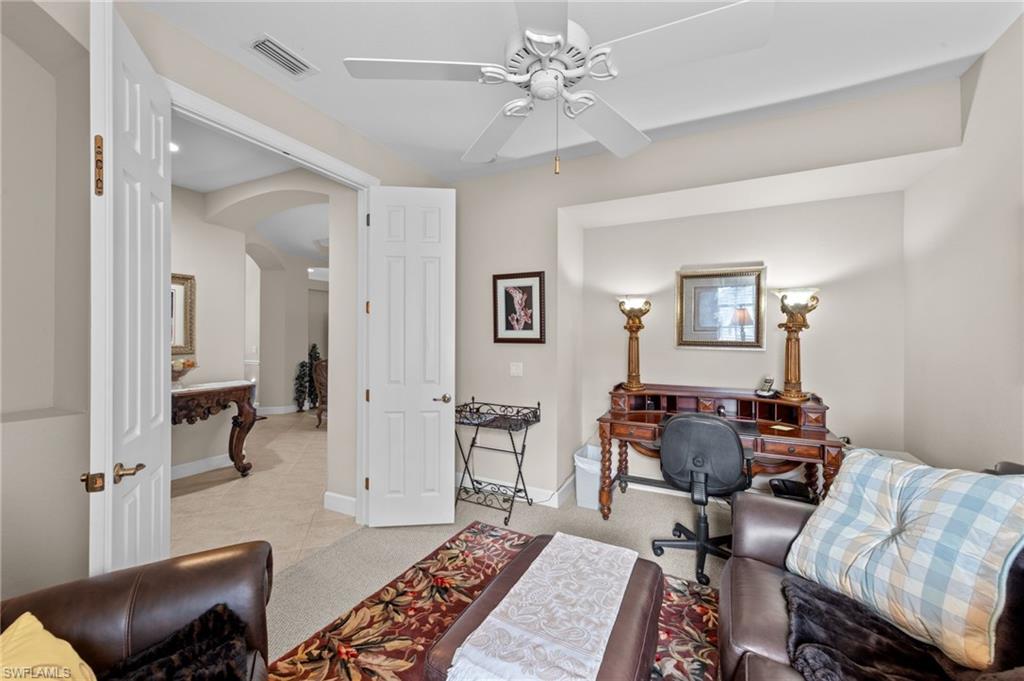 Office with arched walkways, ceiling fan, and light tile patterned floors