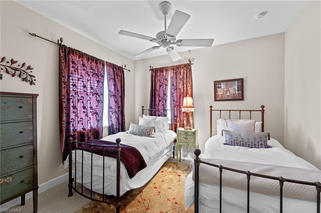 Carpeted bedroom with ceiling fan and baseboards