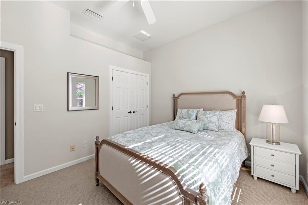 Carpeted bedroom with a closet and a ceiling fan
