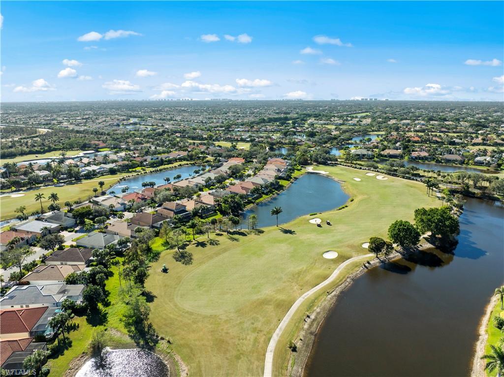 Aerial view of property's location featuring a golf club, nearby suburban area, and a nearby body of water