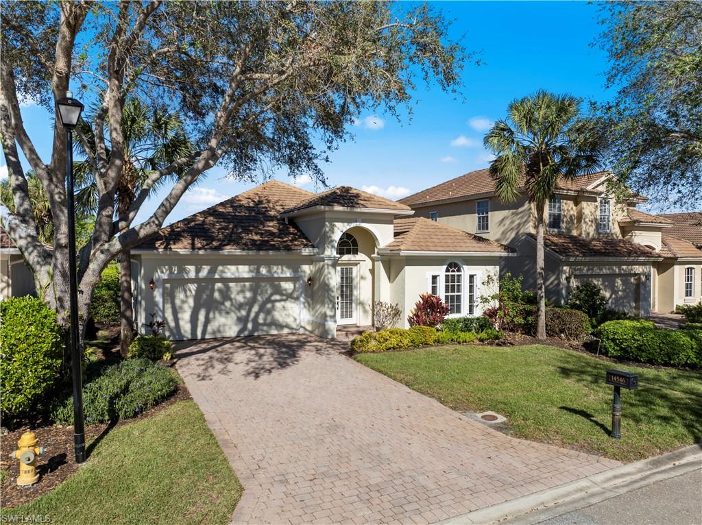 Mediterranean / spanish-style home featuring stucco siding, an attached garage, decorative driveway, and a front yard