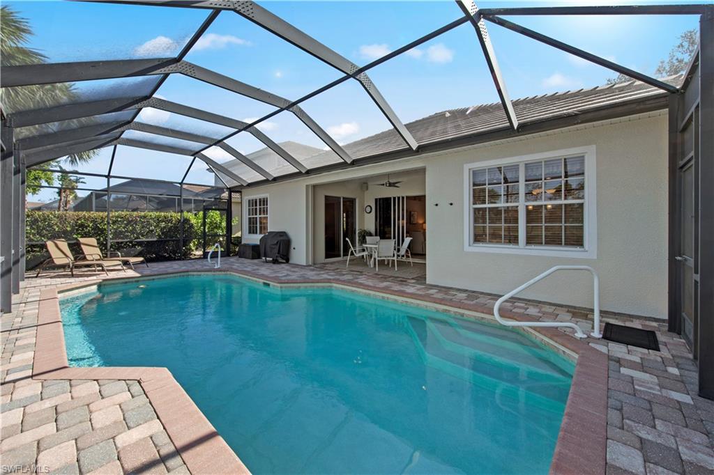 Swimming pool with a patio area, a sunroom, glass enclosure, ceiling fan, and a grill