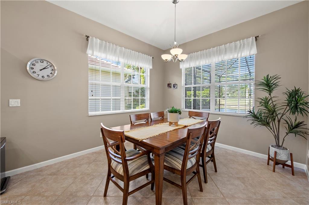 Dining room with light tile patterned floors, healthy amount of natural light, and a chandelier