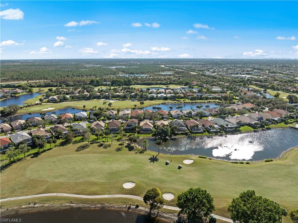 Aerial view of property and surrounding area with nearby suburban area, a nearby body of water, and a golf club