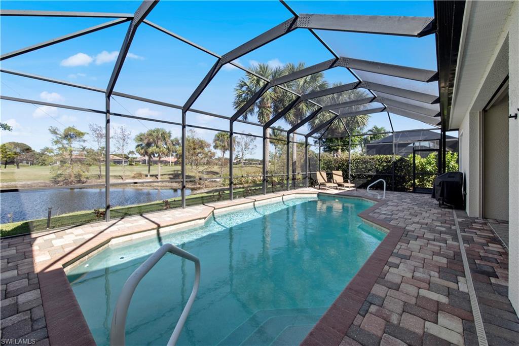 Outdoor pool featuring a sunroom, a patio area, a water view, a lanai, and grilling area