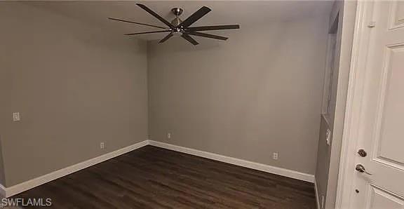 Empty room featuring dark wood-style flooring and a ceiling fan