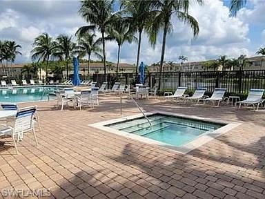 Outdoor pool featuring a community hot tub and a patio