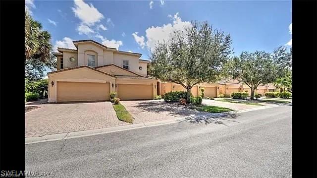 Mediterranean / spanish-style home with decorative driveway, stucco siding, and a garage
