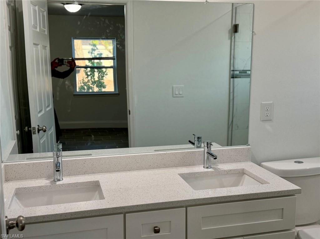 Full bath featuring double vanity and toilet