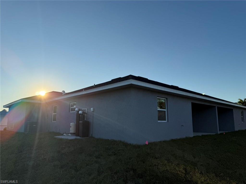 View of side of property with a yard and stucco siding