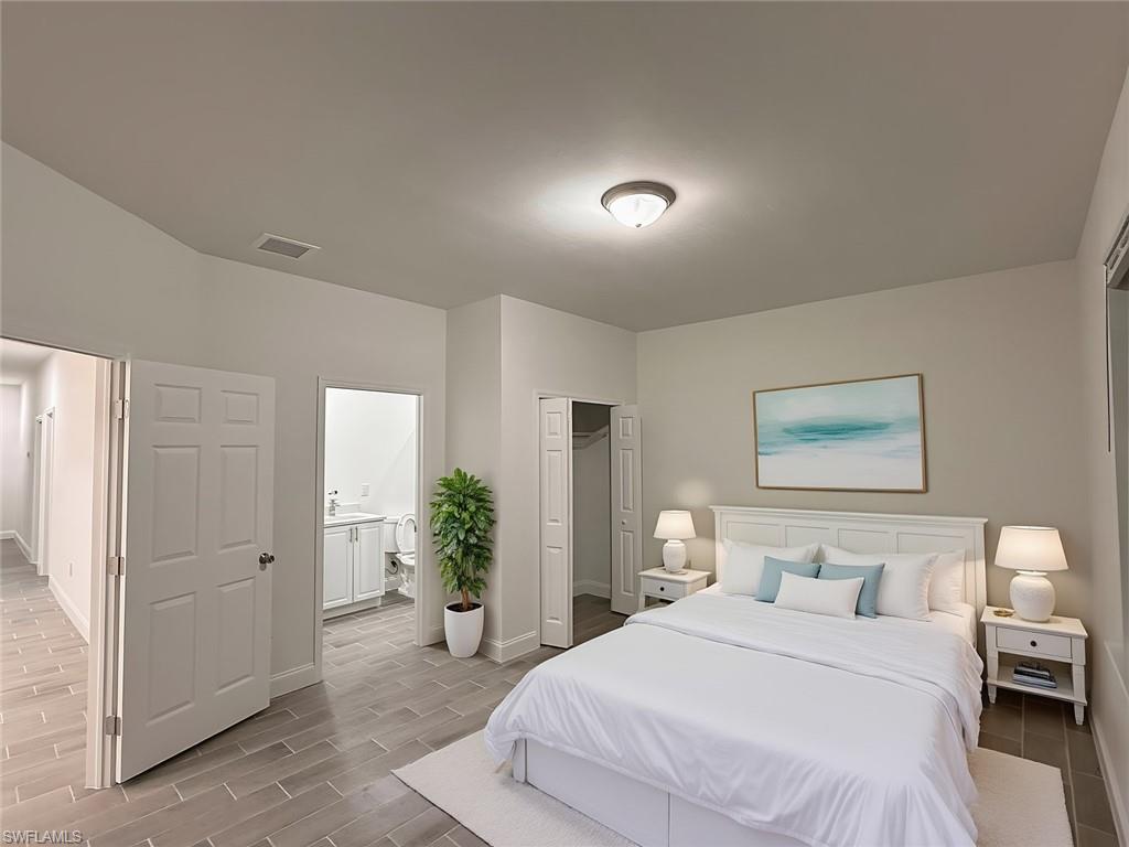 Bedroom with a closet, wood tiled floors, and ensuite bathroom