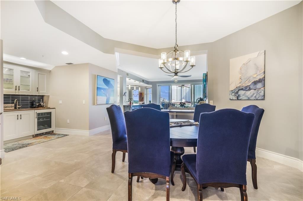 Dining area featuring wine cooler, recessed lighting, a chandelier, and bar area
