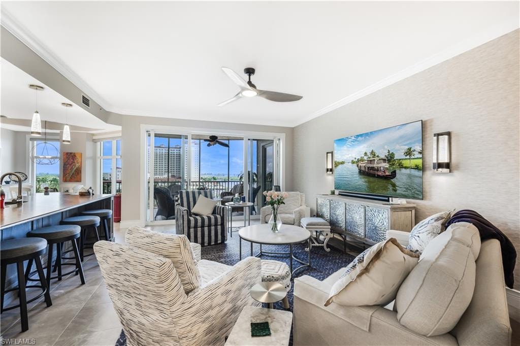 Living area featuring crown molding, a ceiling fan, and light tile patterned flooring