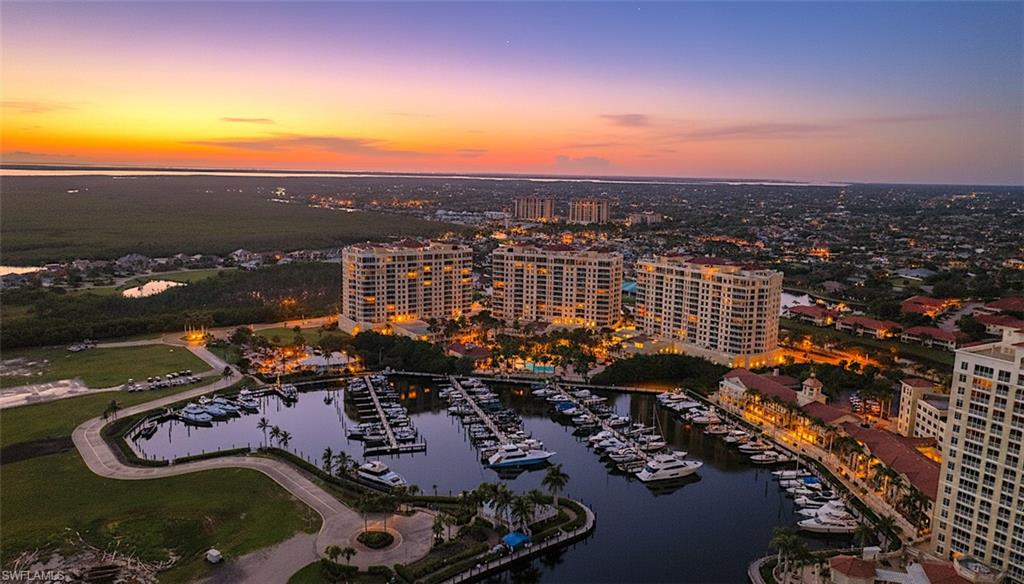 Aerial view of property and surrounding area with a nearby body of water and numerous boat docks